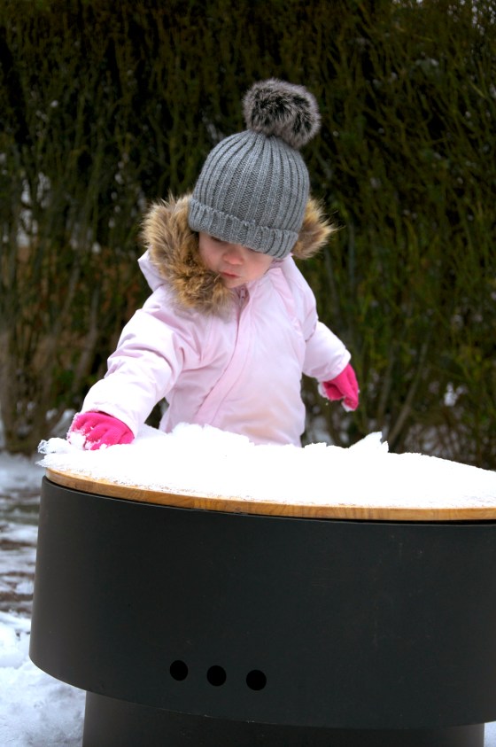 Ava cleaning snow from fire pit